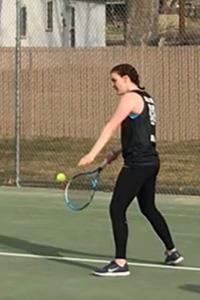 girl serving tennis ball
